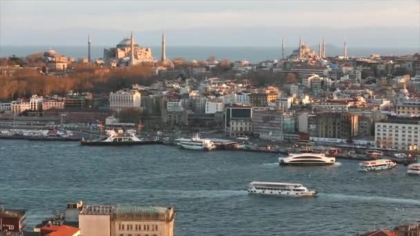 Matahari sore menyinari Masjid Biru dan Hagia Sophia. Sebuah bingkai lebar dari katedral-katedral dan selat Tanduk Emas di malam hari pada jam emas — Stok Video