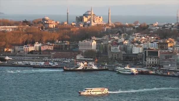 Kvällssolen lyser upp Hagia Sophia. En bred ram av Istanbuls katedraler och Golden Horn sundet på kvällen vid den gyllene timmen — Stockvideo