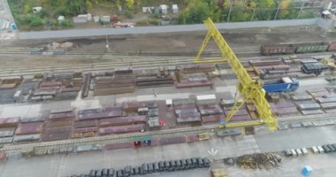 Büyük bir vinçle metal bir deponun üzerinden uçmak, vincin altında bir kamyon.