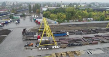 Endüstriyel karmaşık hava manzarası. Büyük bir deponun yakınındaki Gantry vinçleri ve kamyonları. Büyük endüstriyel alan üst görünümü.