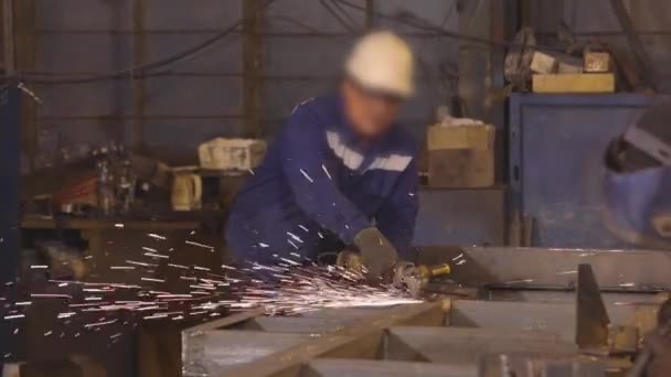 Mann arbeitet als Schleifer in Werkstatt, heller Funken von einem Schleifer — Stockvideo