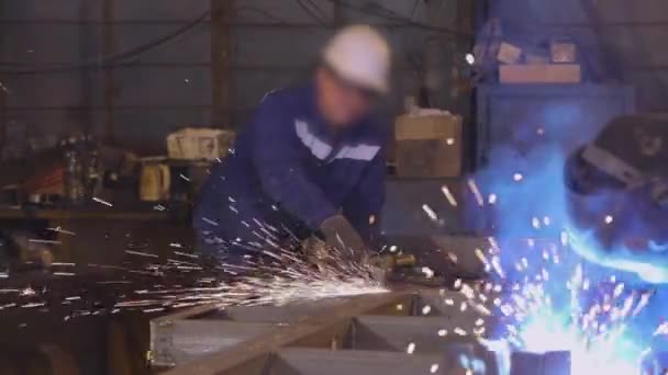 L'uomo lavora come un macinino in un laboratorio, scintille luminose da un macinino — Video Stock