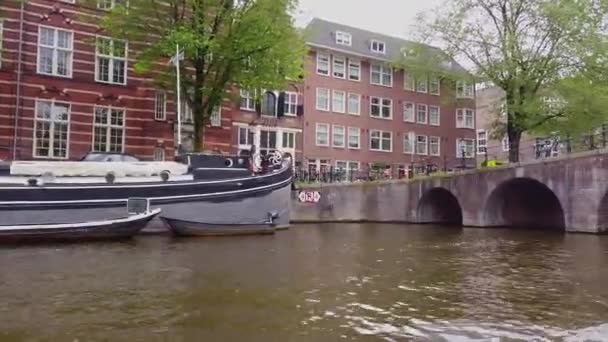 Amszterdam épületeinek külseje. Egy hajón Amszterdamban. Csónakázás az amszterdami csatornák mentén. — Stock videók