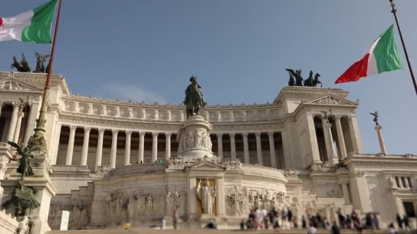 Turistas cerca del Monumento a Víctor Manuel II. Italia banderas cerca del monumento a Victor Emmanuel revoloteando en el viento. Plaza de Venecia en Roma — Vídeos de Stock