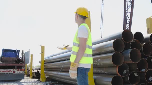 El trabajador da instrucciones a la grúa pórtico, el control de movimiento de la grúa pórtico con la ayuda de gestos, el hombre trabaja en el almacén — Vídeo de stock