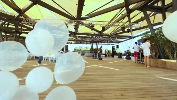 En grupp vita heliumballonger vacklar i vinden — Stockvideo