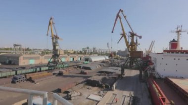 Malzemeleri gemiye yüklemek, kargo gemisine limanda vinç yüklemek. Limanda kargo gemileri yüklüyor.
