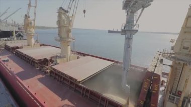 Buğdayı denizden nakledilmek üzere bir kargo gemisine yüklüyorlar. Gemi limanda buğdayla dolu. Buğday ihracatı. Deniz ihracatı. Tarım