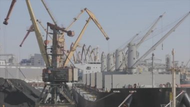 Malzemeleri gemiye yüklemek, kargo gemisine limanda vinç yüklemek. Limanda kargo gemileri yüklüyor.