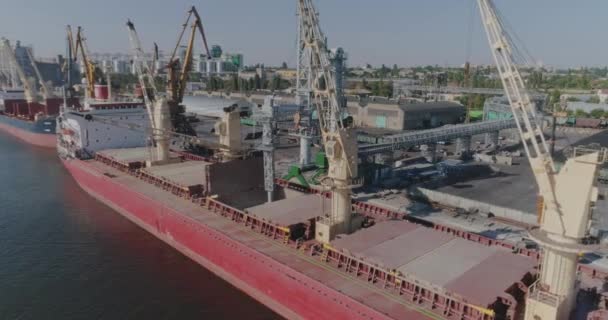 Přístavní jeřáb nakládá náklad do suché nákladní lodi. Suchá nákladní loď v přístavu. — Stock video
