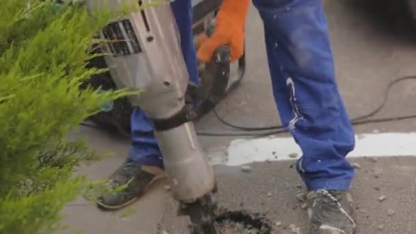 Jackhammer zblízka. Muž udělá díru s kladivem. Demolice silnic s kladivem — Stock video