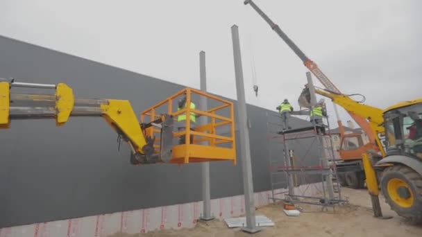 Sitio de construcción, maquinaria en un sitio de construcción, la gente trabaja en un sitio de construcción — Vídeos de Stock