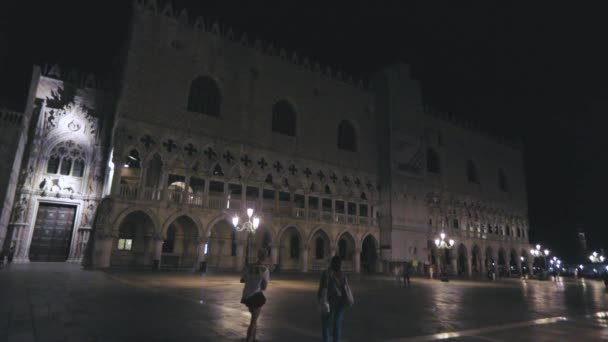 Piazza San Marco à noite plano geral, Veneza. Muitos turistas na Praça de San Marco à noite. Turistas caminham em torno de San Marco à noite. — Vídeo de Stock
