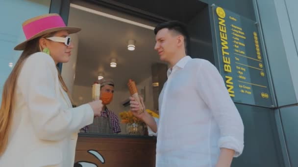 Une fille avec un mec achète un hot-dog. Un couple achète des hot-dogs. Restauration rapide, street food — Video