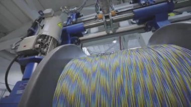 Kablo fabrikası. Yapım aşamasında elektrik kablosunun bobbin kutusuna sarılması. Kablo Pdrodüksiyonu
