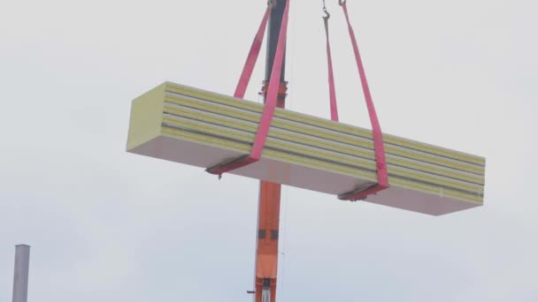 The work of the crane at a construction site, the crane at a construction site raises building material — Stock Video