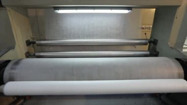 Dokumasız kumaş ruloları tüpe itiliyor. Örülmemiş kumaş üretimi