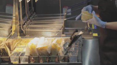 Fast food, patates kızartması. Bir adam patates kızartması yapar. Patates kızartması pişiriyorum.,
