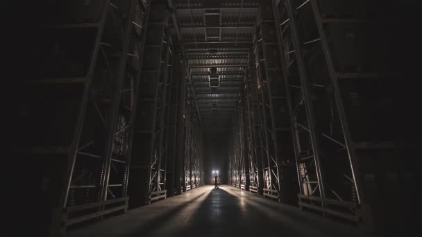 Zu Beginn des Arbeitstages in der Fabrik gehen Männer mit einem Trolley durch das Lager — Stockvideo