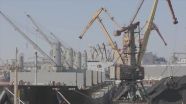Malzemeleri gemiye yüklemek, kargo gemisine limanda vinç yüklemek. Limanda kargo gemileri yüklüyor.