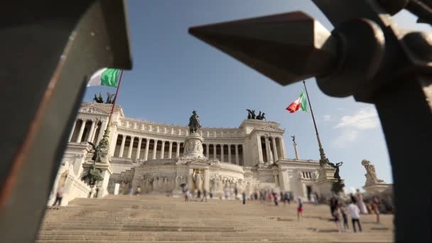 Vlaggen van Italië wapperen in de wind. Vierkant van Venetië in Rome. Toeristen in de buurt van het monument voor Victor Emmanuel II — Stockvideo