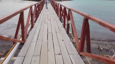 Bir adam köprüden geçiyor, bir köprü, bir göl köprüsü, patagonya 'da bir göl üzerinden.