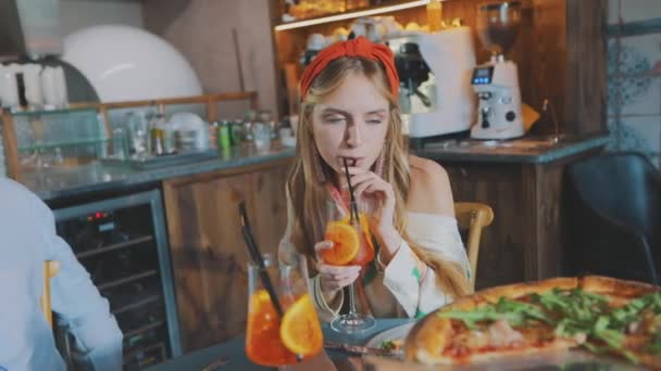 Killen med flickan dricker cocktails i en pizzeria. Dejtkille med en tjej i pizzeria — Stockvideo
