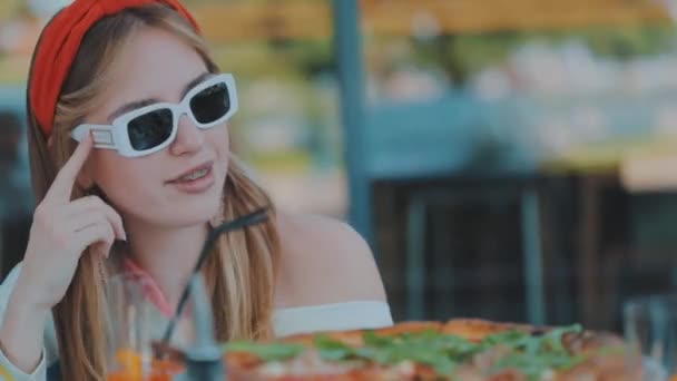 Hermosa chica posando para la cámara, una joven con gafas posando para la cámara — Vídeos de Stock