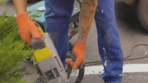 Road demolition with a jackhammer. A man makes a hole with a jackhammer. Jackhammer close-up, — Stock Video