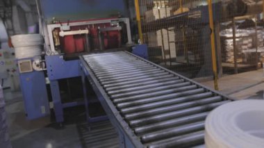 Modern bir konveyörde kabloyla makaraları paketlemek, otomatik makaraları kabloyla sarmak, fabrikada modern otomatik taşıyıcı.