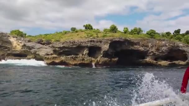 Una barca a motore naviga lungo belle scogliere, una barca a motore naviga lungo le onde lungo le scogliere — Video Stock