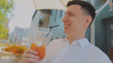 Gençler meyve suyu içer. Kız ve erkek meyve suyu içiyorlar. Meyve suyu restoranda bir masada.