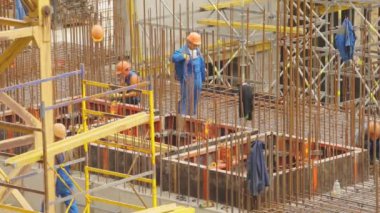İnşaat alanında çalışanlar. İnsanlar yeni bir evin inşaatı üzerinde çalışıyorlar. Güçlendirilmiş Beton İnşaat