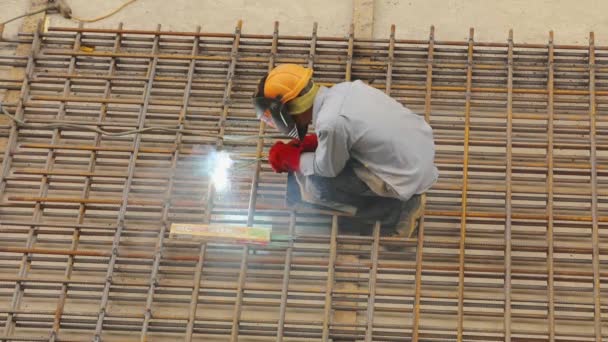 Construcción del marco de acero. Soldador en una obra de construcción. Chispas de soldadura — Vídeos de Stock