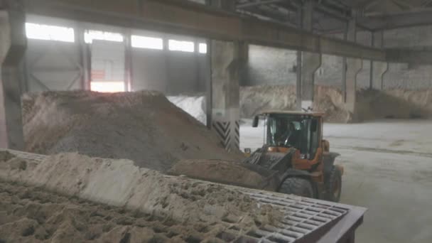 Chargement de matériaux sur le convoyeur Un bulldozer charge du sable sur une ligne de convoyage. — Video