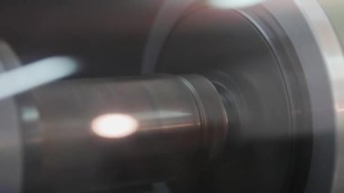 Yakından kayan şaft. Yeni modern ekipmanlar. Modern duvar kağıdı üretimi. Duvar kağıdı üretiminin büyük rulolarını kapat.