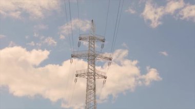 Elektrik taşıma hattı. Yüksek voltajlı kule. Elektrik direklerinin arka planında güzel bulutlar var. Elektrik taşıma hattı. Yüksek voltajlı kule