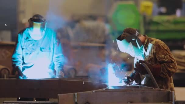 Ein Arbeiter in einer Fabrik schweißt eine Metallkonstruktion zusammen. Fabrikschweißer — Stockvideo