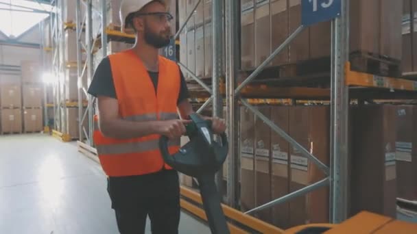 Trabajador de almacén transporta carga. Empleado de almacén transporta cajas — Vídeos de Stock