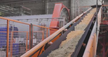 Kum ve metal toplarla taşıma bandı. Fabrikadaki taşıma bandı hattı.
