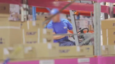 Büyük bir depoda forklift. İnsanlar depoda çalışıyor. Endüstriyel iç