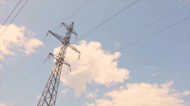 Elektrik taşıma hattı. Yüksek voltajlı kule. Elektrik direklerinin arka planında güzel bulutlar var. Elektrik taşıma hattı. Yüksek voltajlı kule