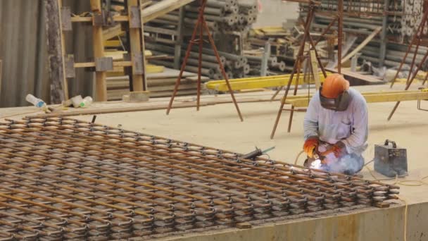 Um soldador solda uma estrutura metálica. Soldador de construção. Construção de metal de solda. — Vídeo de Stock