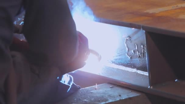 Un trabajador de una fábrica suelda una estructura metálica. Soldador de fábrica — Vídeos de Stock