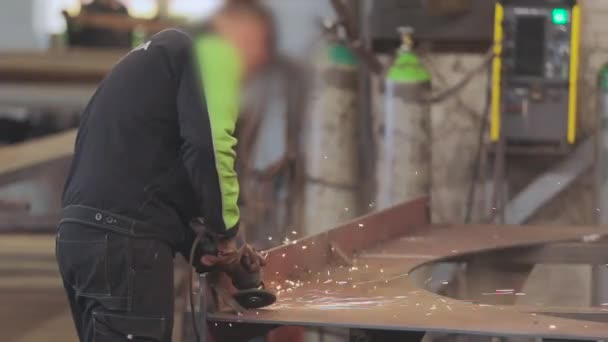 Los hombres realizan trabajos de metal en un taller, chispas brillantes de una herramienta de trabajo — Vídeos de Stock