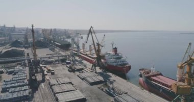 Büyük bir sanayi limanının üzerinde uçuyor. Uluslararası sanayi limanı, vinçler ve kargo gemileri