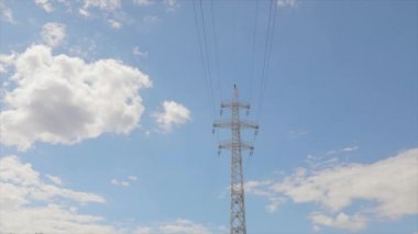 Elektrik taşıma hattı. Yüksek voltajlı kule. Elektrik direklerinin arka planında güzel bulutlar var. Elektrik taşıma hattı. Yüksek voltajlı kule