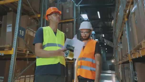 Dos personas en el almacén están discutiendo algo. Dos ingenieros en un almacén moderno. — Vídeo de stock