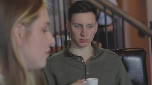 Una pareja joven en una cita. Un tipo con una chica en una cita en un café. — Vídeo de stock