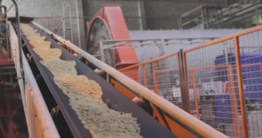 Kum ve metal toplarla taşıma bandı. Fabrikadaki taşıma bandı hattı.